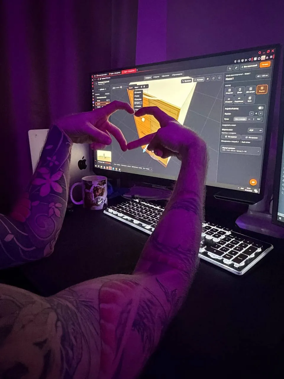 Основатель Уют3D показывает сердечко из рук на фоне монитора с редактором